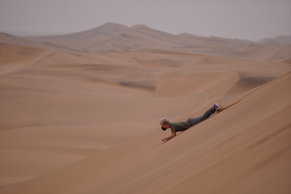 Sandboarding down the dunes near Swakopmund Namibia