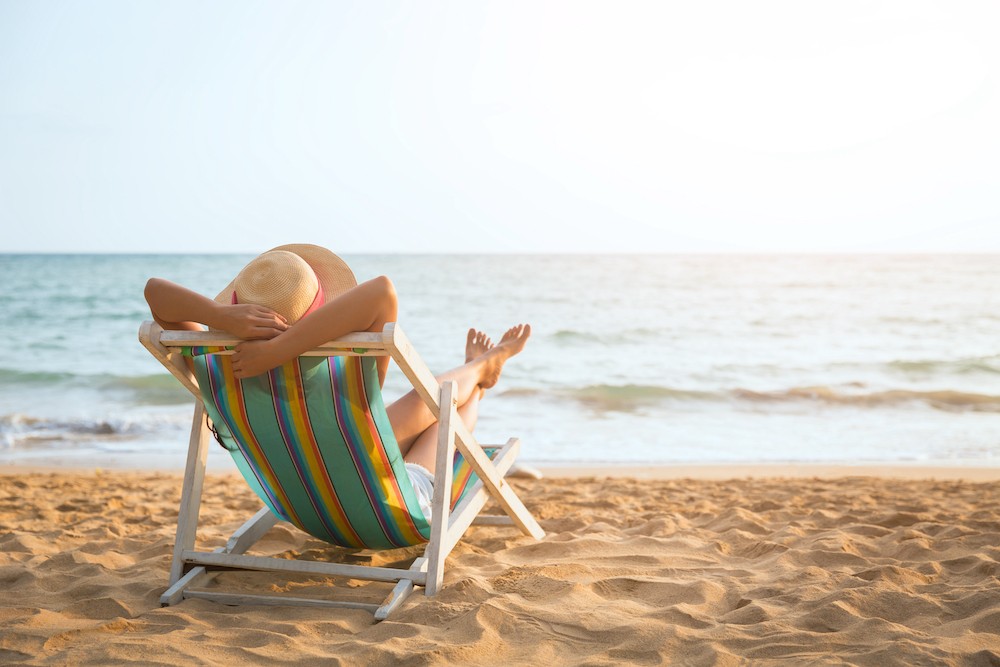 Summer beach vacation concept, Asia woman with hat relaxing and arm up on chair beach at Koh Mak, Trad, Thailand