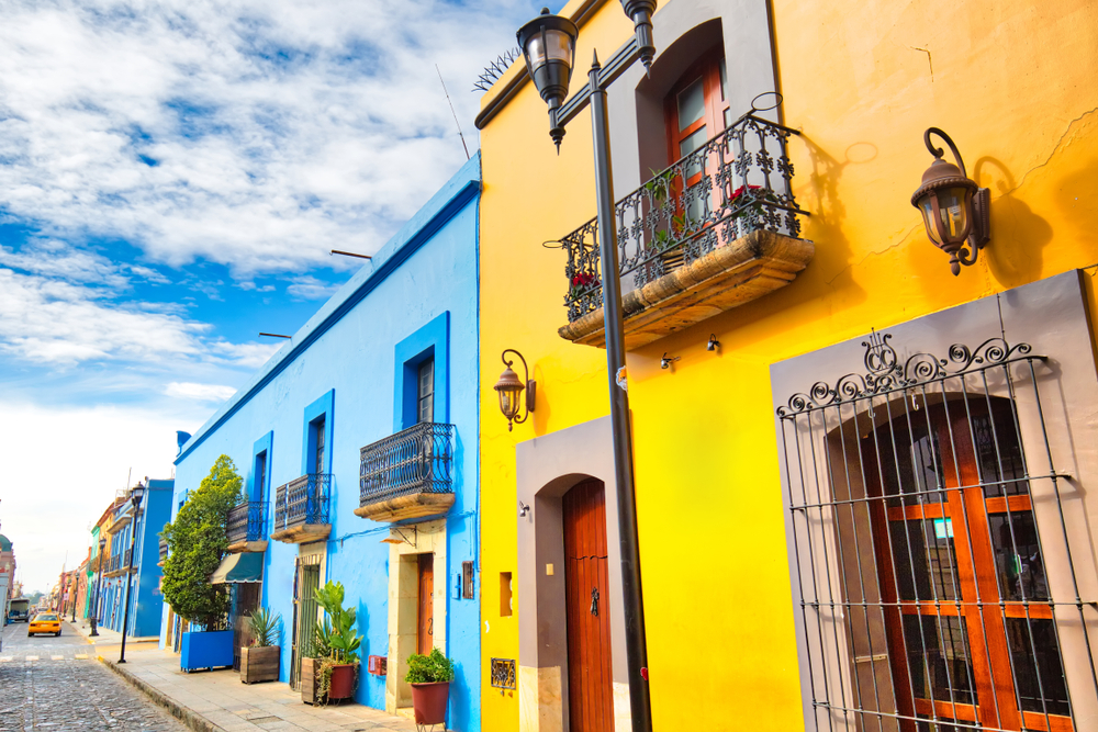 Scenic old city street and colorful colonial buildings in Oaxaca City, Mexico.