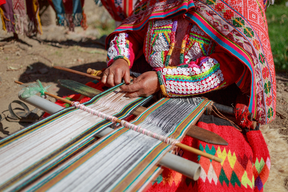 The woman weaving multi-colored fabrics in Huillos, Sacred Valley, Peru.