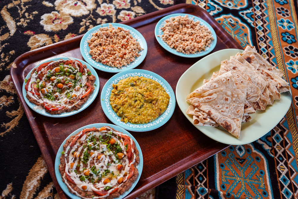 Delicious dishes of traditional omani food served on carpet in traditional restaurant, Oman.