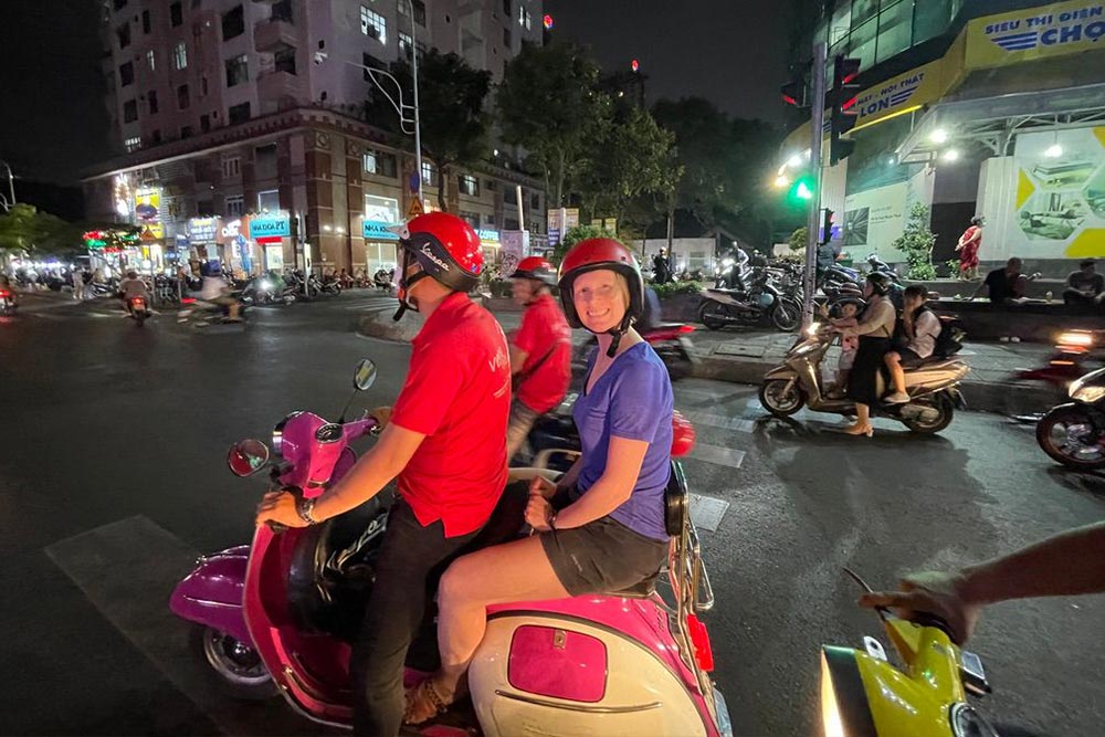 Brook on a Vespa in Saigon, Vietnam at night.