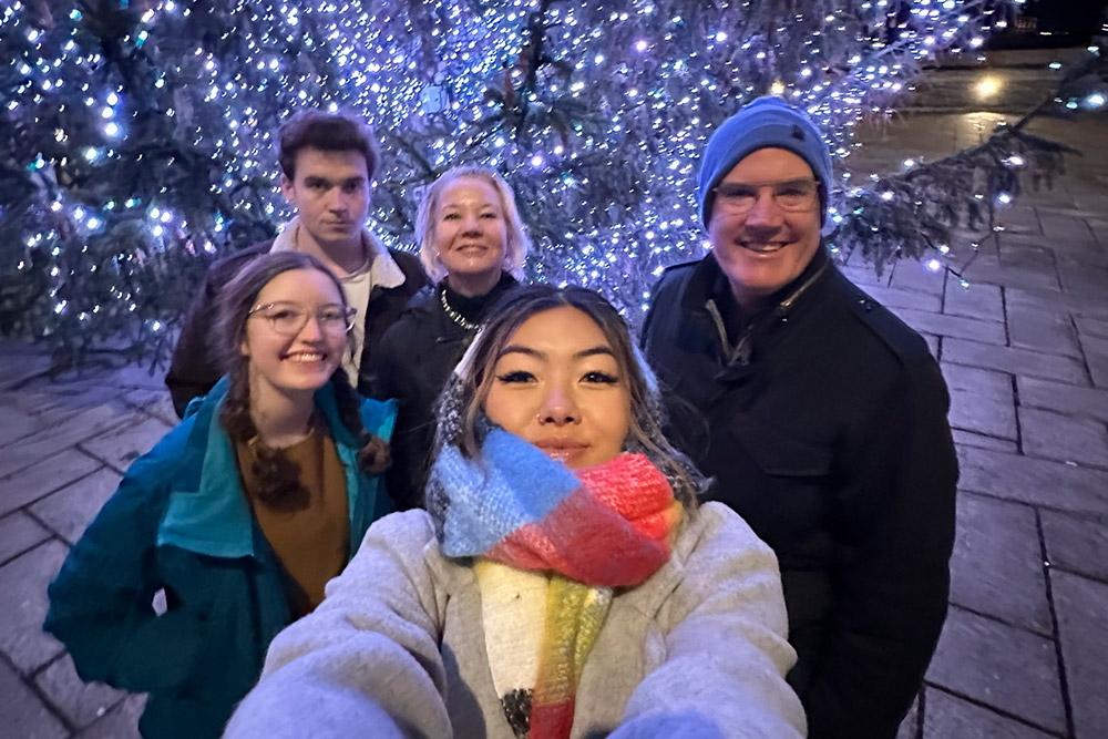 A selfie of Philip Goldman and his family in Italy with a Christmas tree in the background.