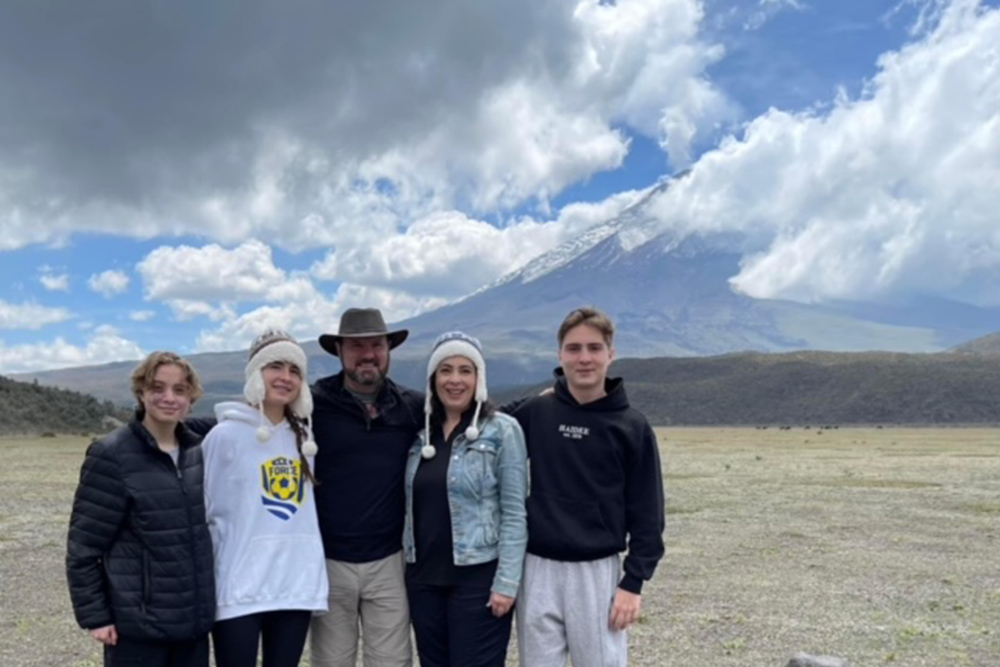 Robyn Smyers and family in Galapagos with a beautiful landscape in the background.