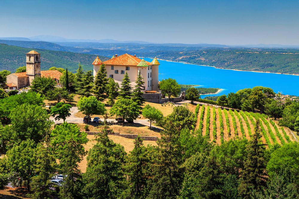 Sunny day in Provence with Aiguines castle surrounded by vineyard and the beautiful turquoise St Croix lake in background.