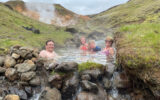 Brook Wilkinson and her family enjoying hot springs with beautiful mountains in the background.