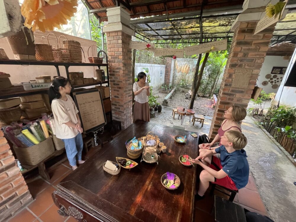 Deaf women at Lavin Home in Hue, Vietnam teach Brook and Zeke how to make paper flowers.