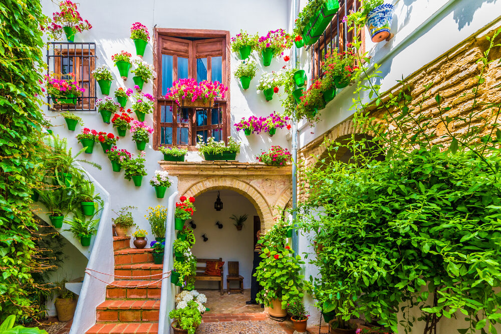 Traditional house and colorful flower-laden patios in Cordoba, Spain.