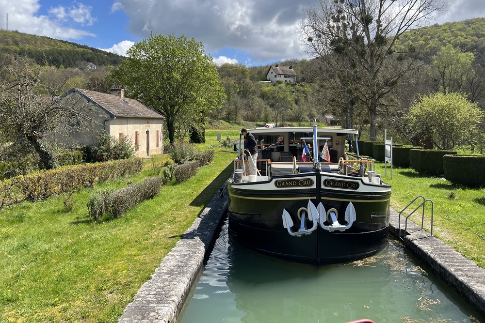 The barge passing a lock house on the Burgundy Canal, France.