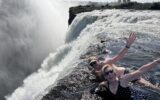 Travelers swimming in the Devil's Pool at the top of Victoria Falls, in Zimbabwe