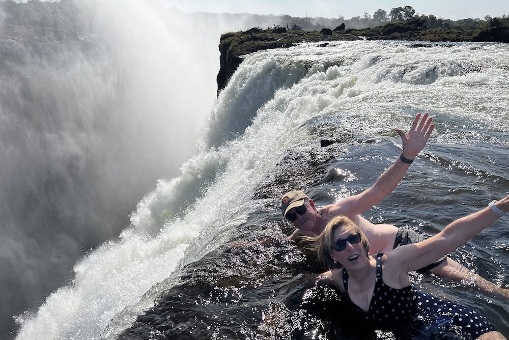Travelers swimming in the Devil's Pool at the top of Victoria Falls, in Zimbabwe