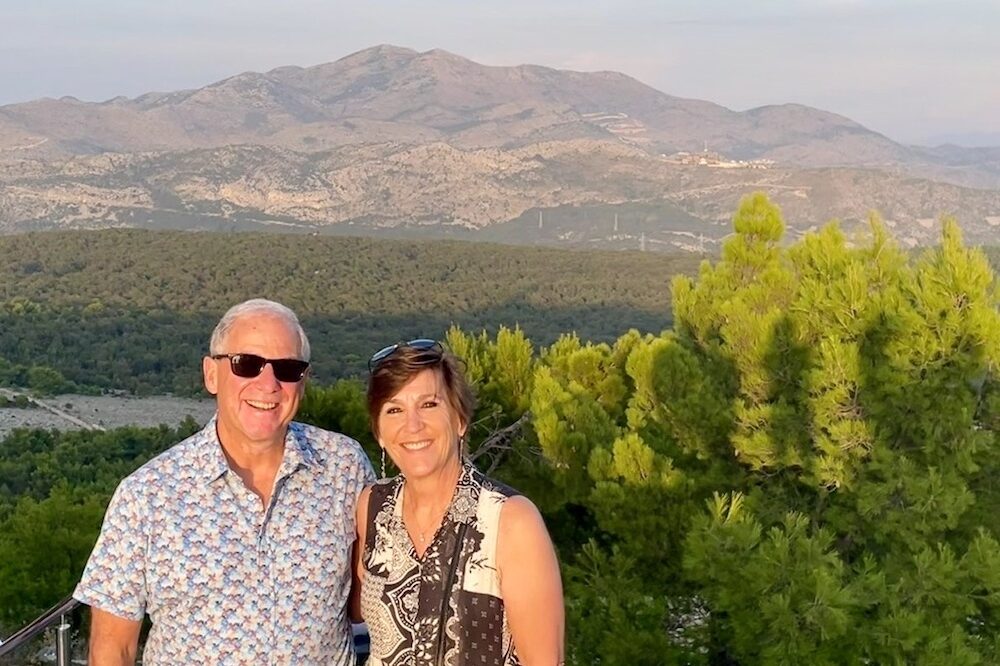 Couple posing at the top of a mountain in Dubrovnik, Croatia, following a cable car ride