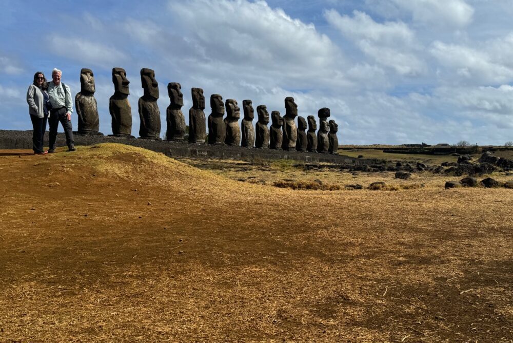 Travelers posing beside the Tongariki moai on Easter Island. 