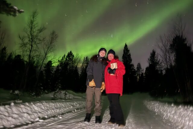 Kate Ogg and son Will see the northern lights from the driveway of their lodge in Alta.