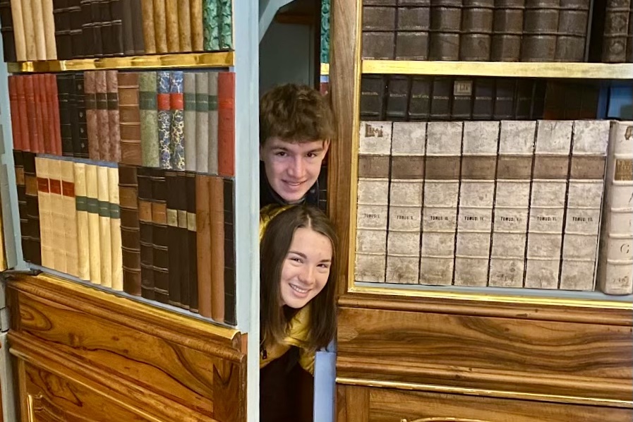 Kate and Will Nury peek out of a secret stairwell in Prague's Strahov Monastery.