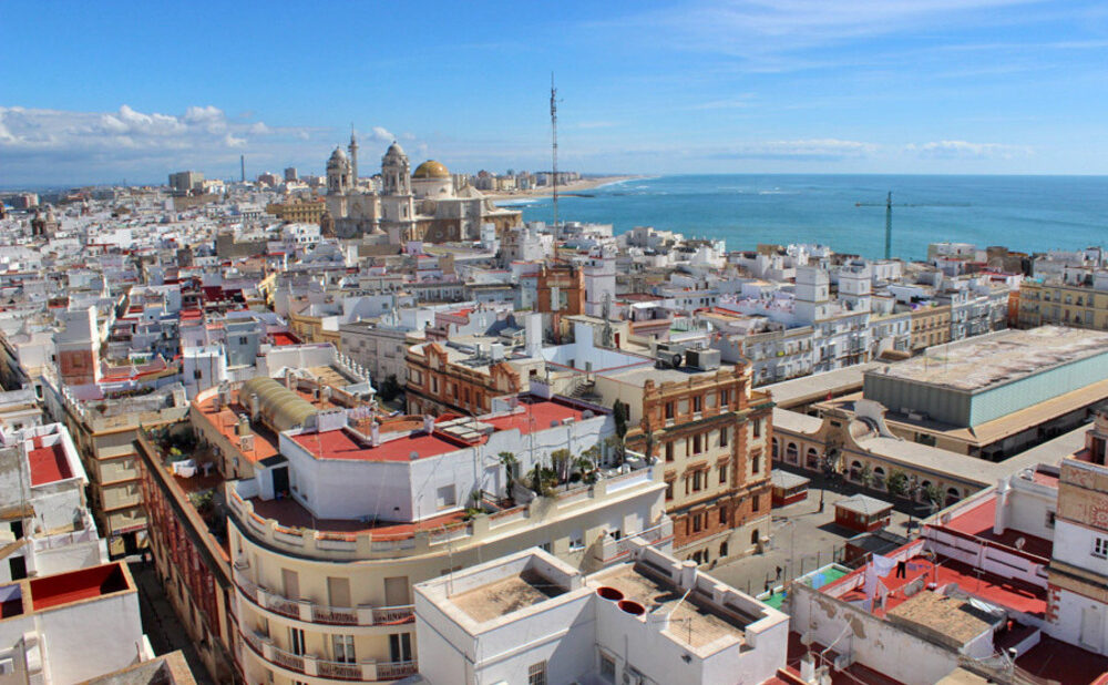 Panoramic view of the old city rooftops in Cadiz on a sunny day with a view of the ocean.
