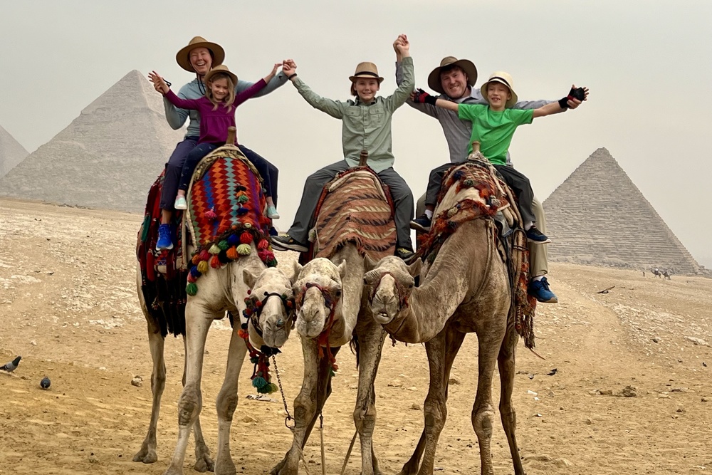 Travelers on a camel ride near the Pyramids of Giza.