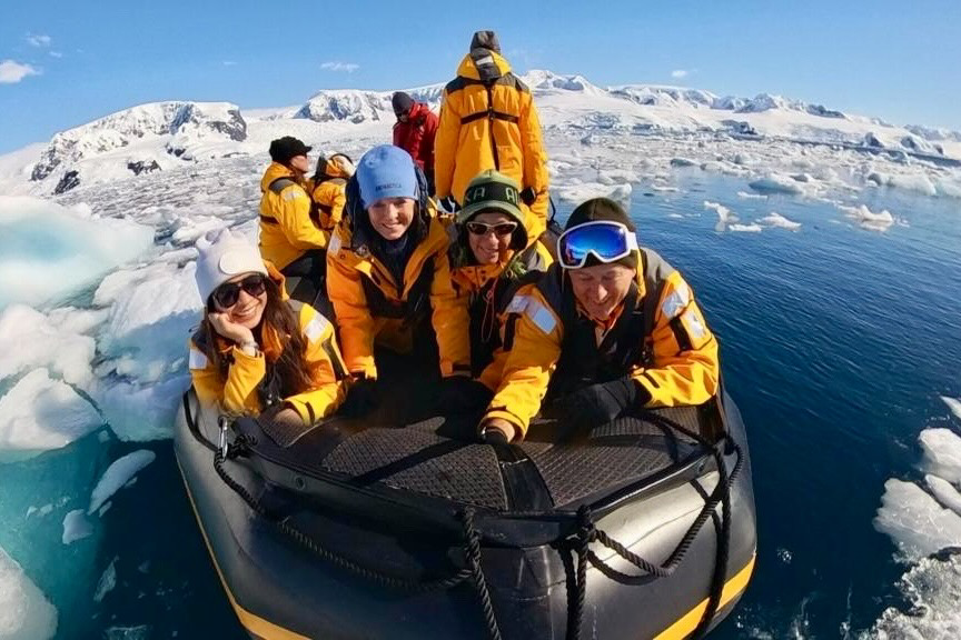 Travelers exploring Antarctica's ice by zodiac.