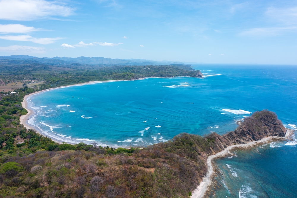 Wavy Garza beach inn Costa Rica, surrounded by mountains.