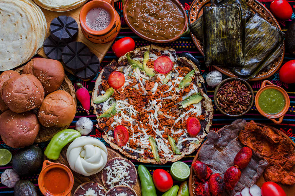 A platter of traditional food from Oaxaca including tamales, tlayudas, and more.