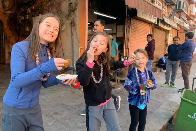 Girls tasting jalebi, a traditional Indian sweet.