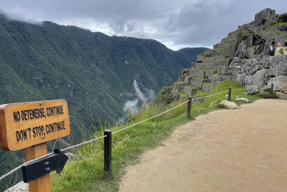 Low-profile ropes and signage guide visitors around the ruins of Machu Picchu.