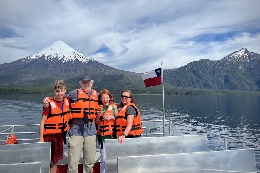John Strachan and his family cruising on Lago Todos los Santos with Volcán Osorno in the background, Chile.