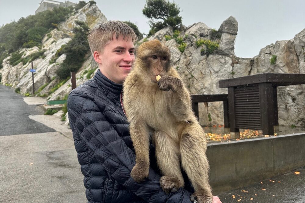 Julie Heimark's son taking a photo with Gibraltar's macaques in Spain.