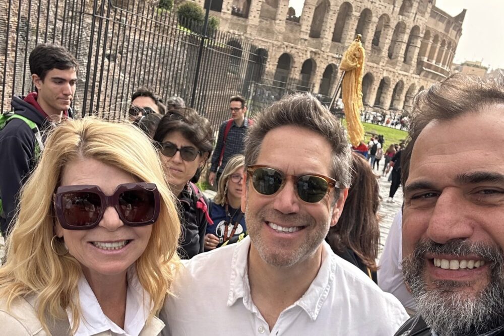 Traveler Sarah Cohen with her husband and guide Salvatore in Rome with the Colosseum in the background.