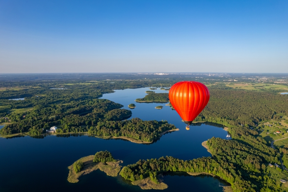 Aerial view of a hot air balloon on a clear sunny day over Galve Lake in Lithuania.