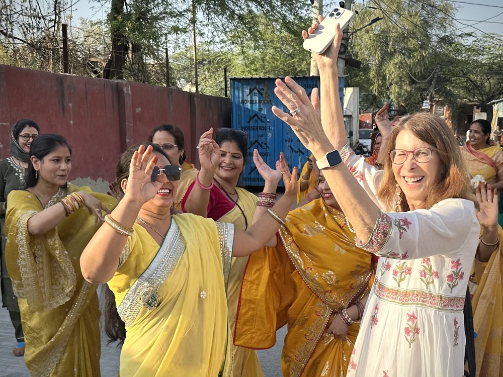 Andrea Klausner dancing with local women in India.