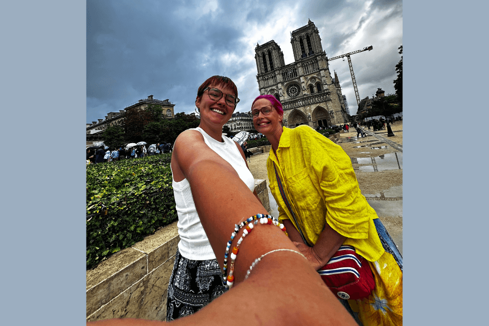 Robyn Needham and her daughter taking a selfie in Paris, with Notre-Dame Cathedral in the background.