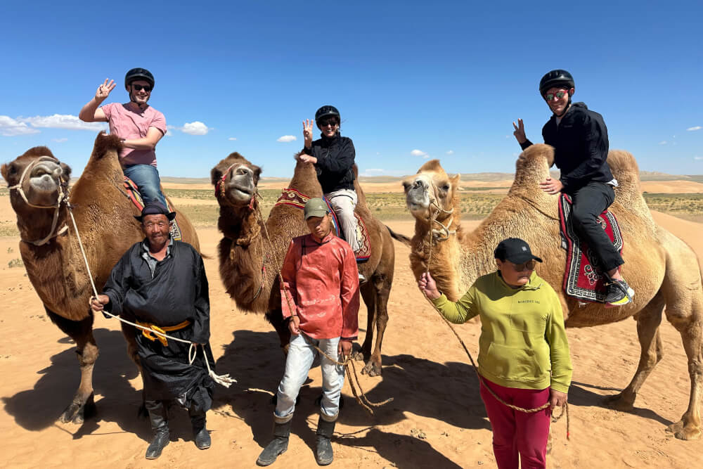 Barbara Schoenfeld and her sons, Alex and Gordon riding camels in the Gobi Desert, Mongolia.