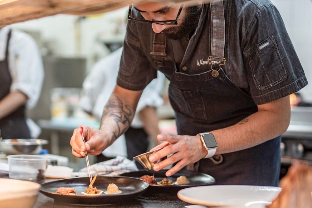 Chef planting food on plate, Zazu Restaurant in Ecuador.
