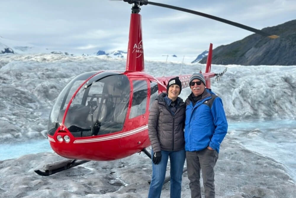 Ken Gerstein and his wife next to a helicopter in Alaska.