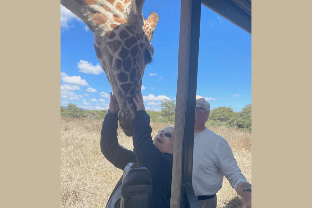 Sandy Collins and her husband Art meeting a giraffe in Kenya.