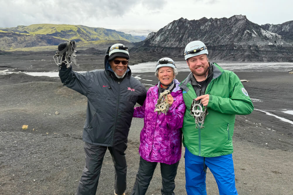 Stephen Thomas, Sandra Quinn, and Brian Quinn showing their crampons during a glacier walk in Iceland.