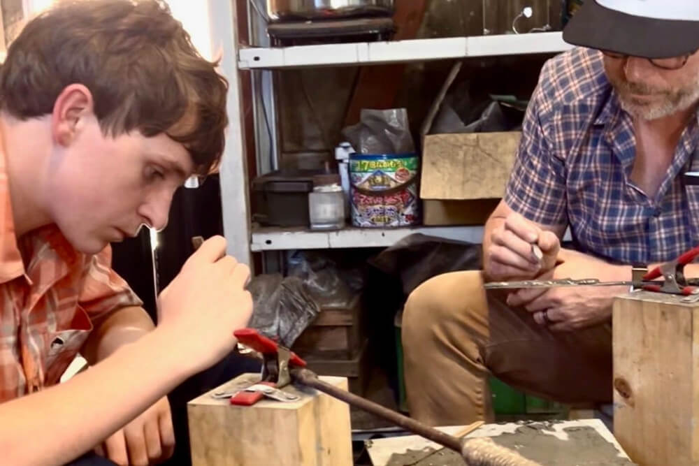 Travelers designing swords with a swordsmith in Japan.