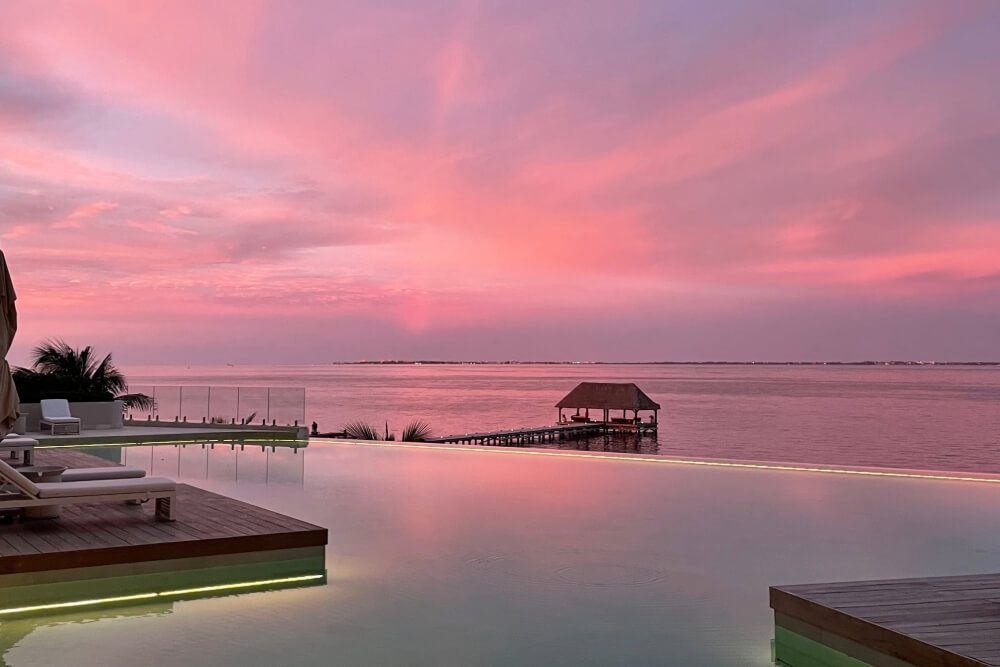 Sunset over the coastline and resort infinity pool after a rainstorm in Cancun, Mexico.