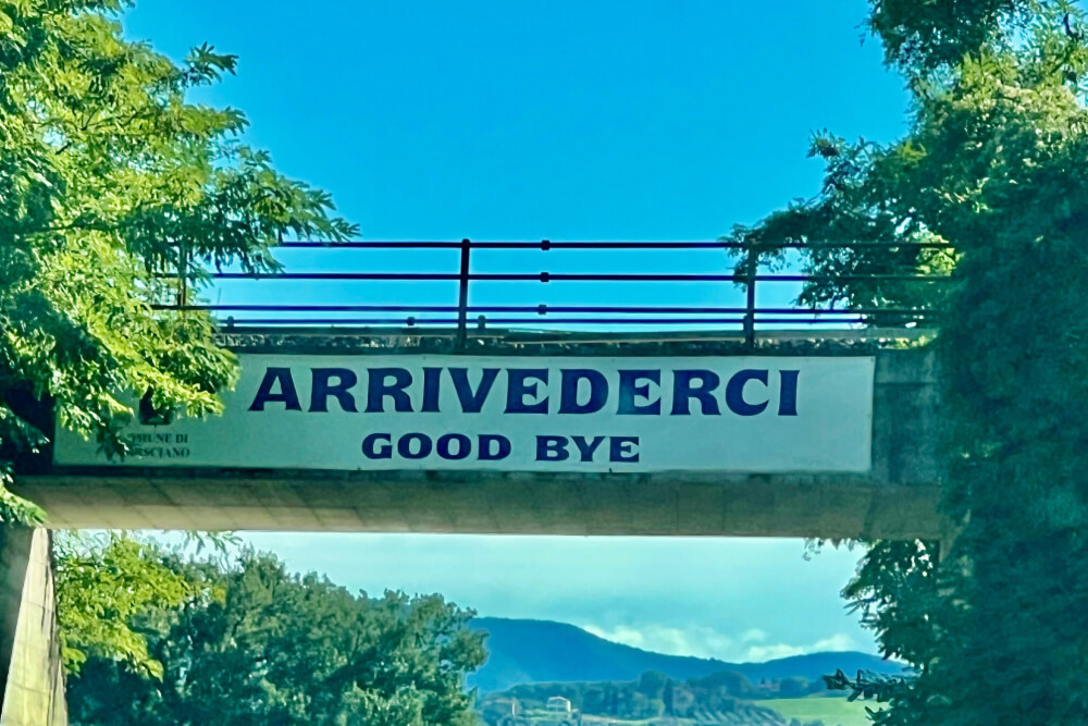 "Arrivederci" sign on a bridge in Italy.