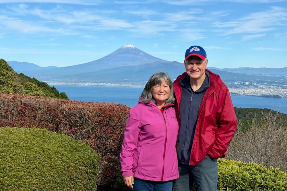 Bruce Tylock and his wife hiking on the Izu Peninsula with a view of Mt. Fuji.