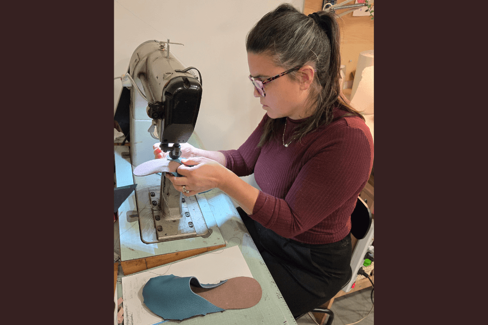 A woman sewing leather slippers at a shop in Pesaro, italy.