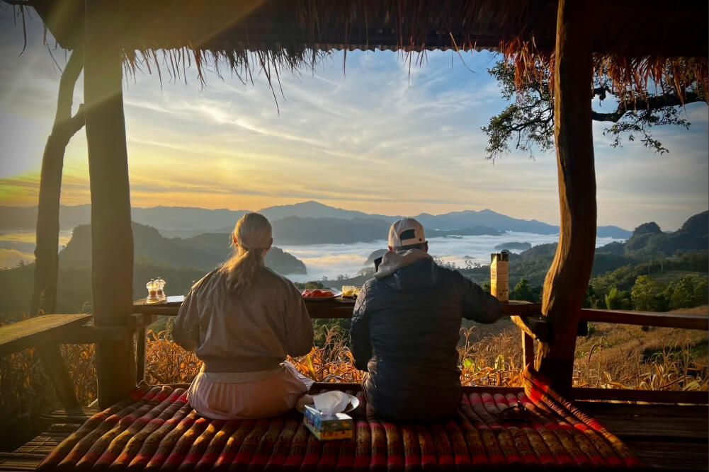 Amy and Chad having breakfast and watching the sun rise across the valley in Thailand.