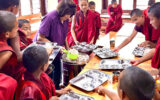 Jan Heininger and her husband at a monastery in Bhutan, serving lunch to monks.