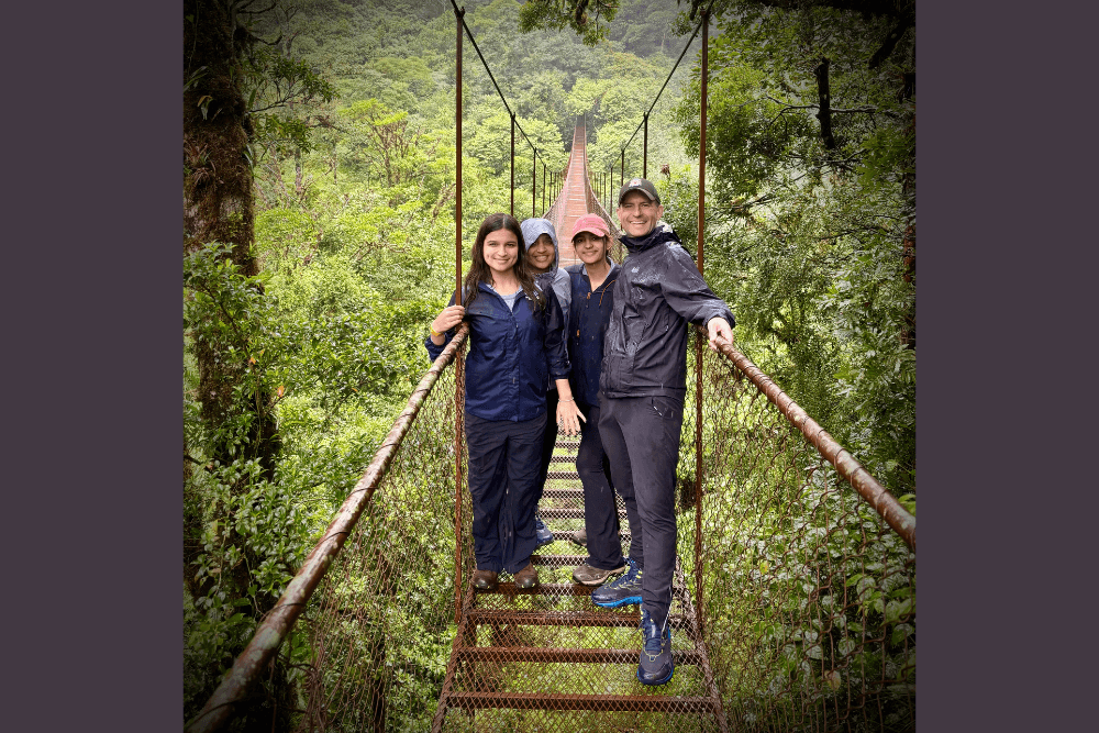 Samuel Lada and his family walking a high bridge in the Cloud Forest, Panama.