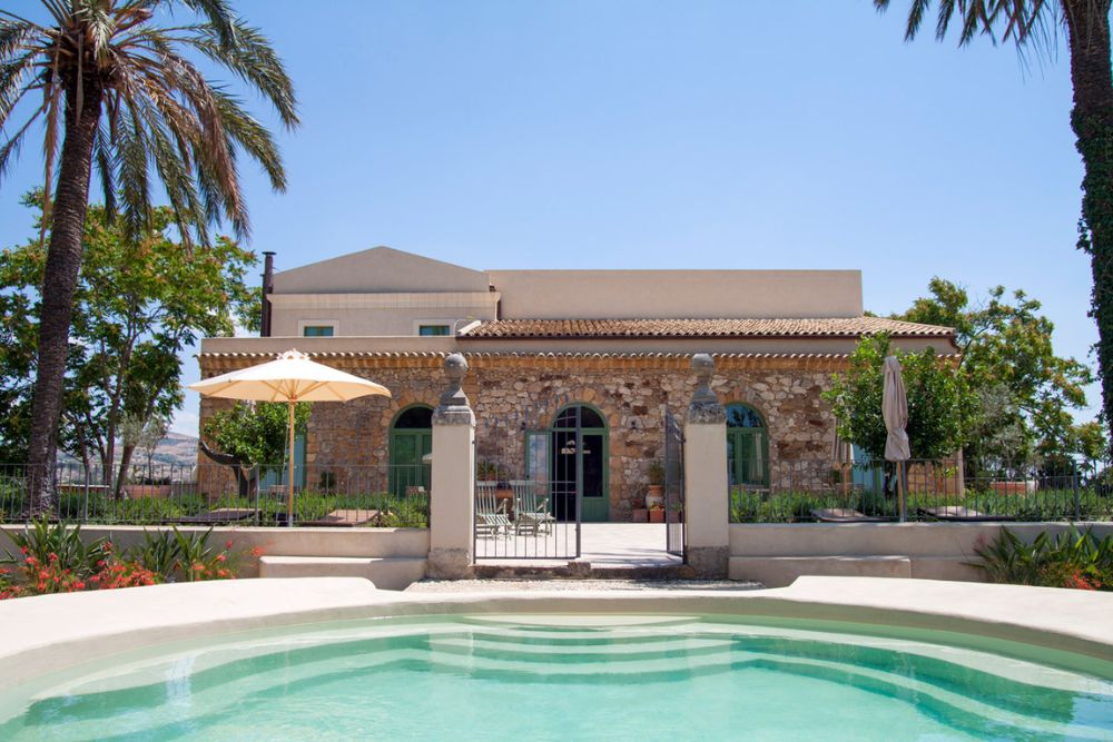 The pool, palm trees, and the bio resort of Fontes Episcopi in Sicily, Italy. 