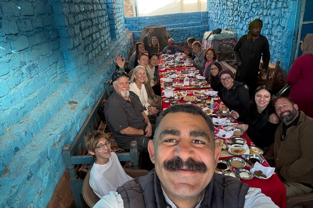 Deborah Wente and family having breakfast with locals at at their home on Bisaw Island, Egypt.