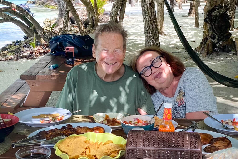 Miriam Morris and her husband Lorne enjoying a barbecue during a catamaran sail to Moho Caye, Belize.