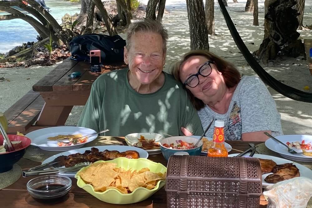Miriam Morris and her husband Lorne enjoying a barbecue during a catamaran sail to Moho Caye, Belize.
