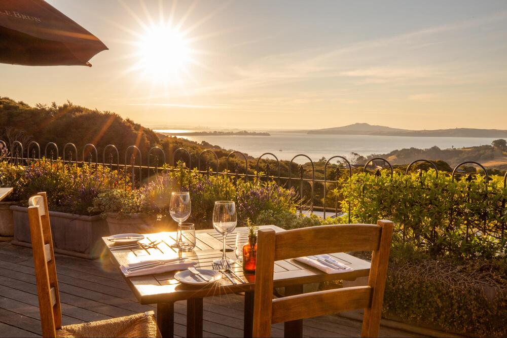 Outdoor restaurant table overlooking vineyards on Waiheke Island, New Zealand.